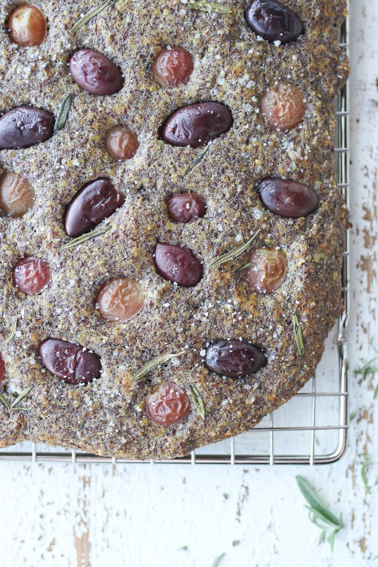 Close up of gluten free focaccia bread with flax on a baking rack. 