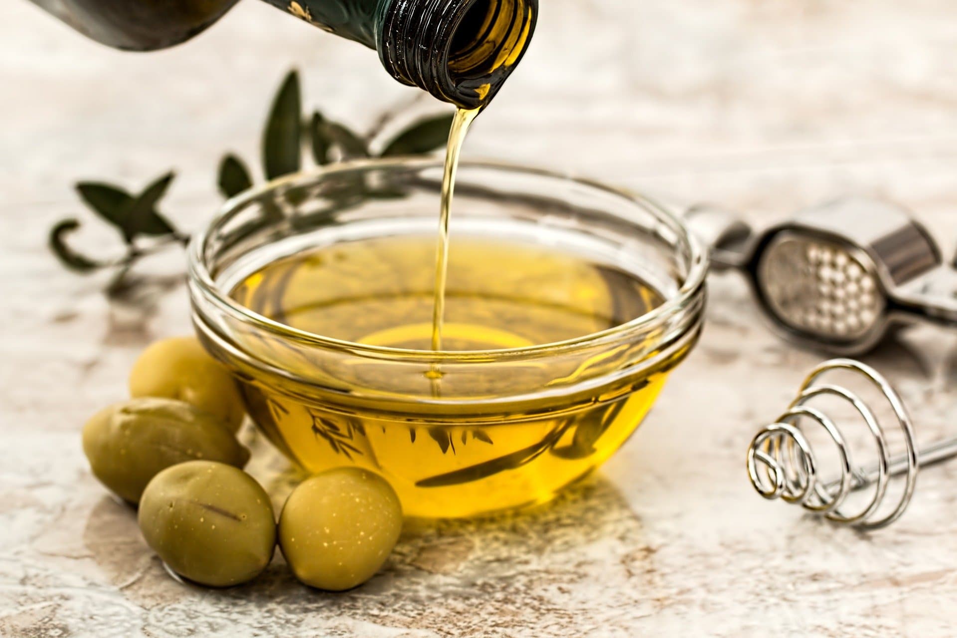Drizzling olive oil into a bowl.