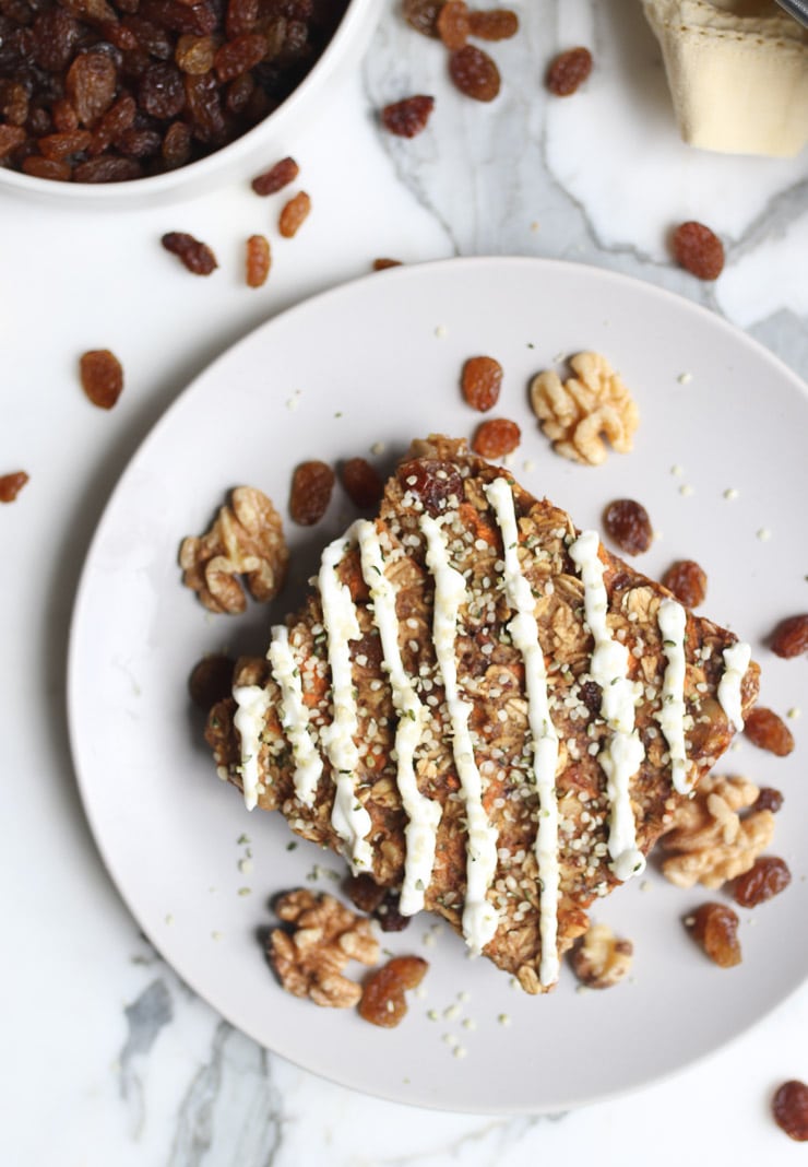 Birds eye view of baked carrot cake oatmeal breakfast topped with walnuts and raisins.