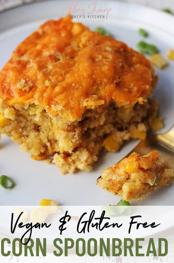 close up image of vegan corn spoonbread garnished with corn and green onions next to a silver fork with text overlay