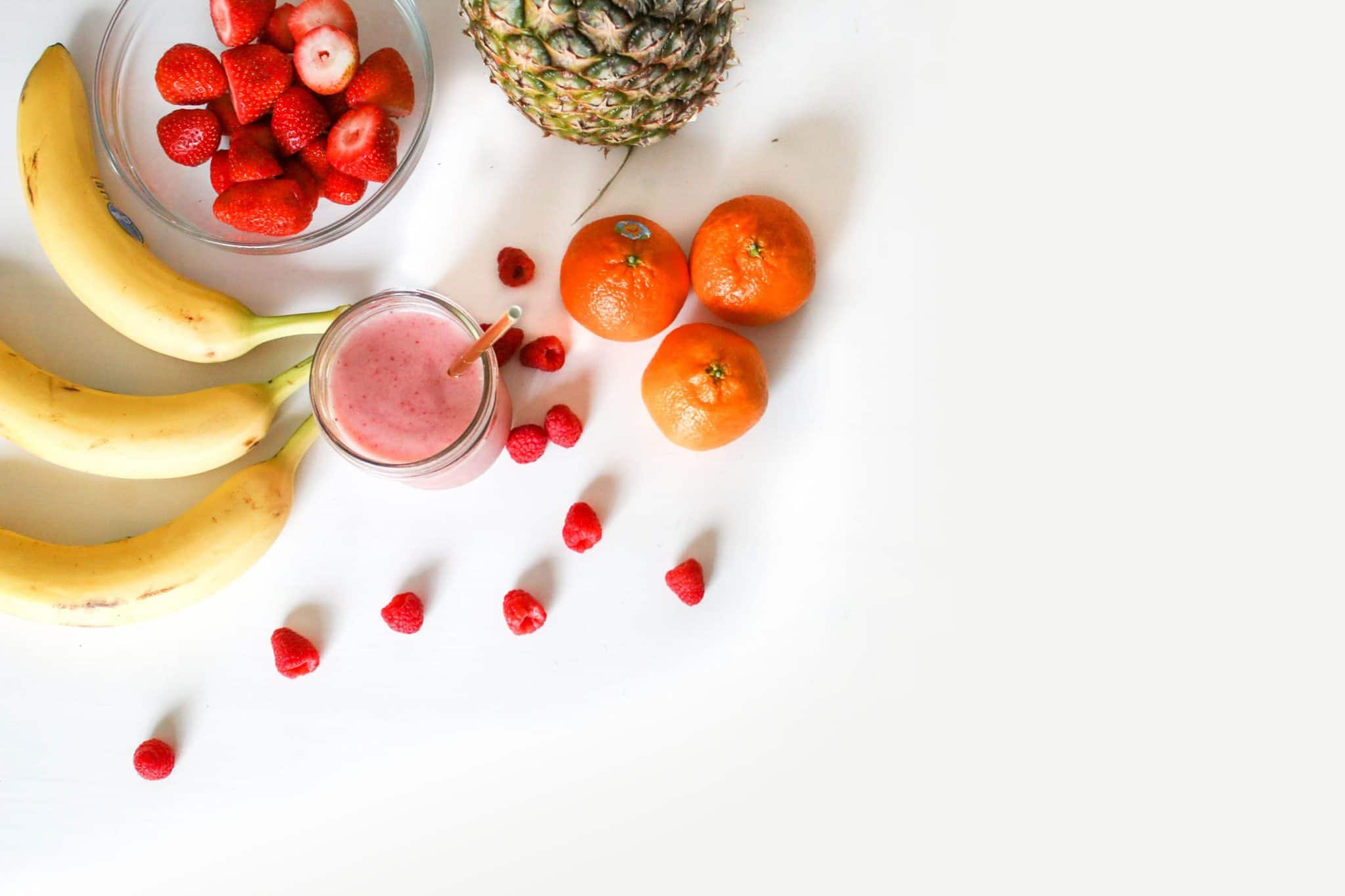 birds eye image of multiple fruits and vegetables on a white surface