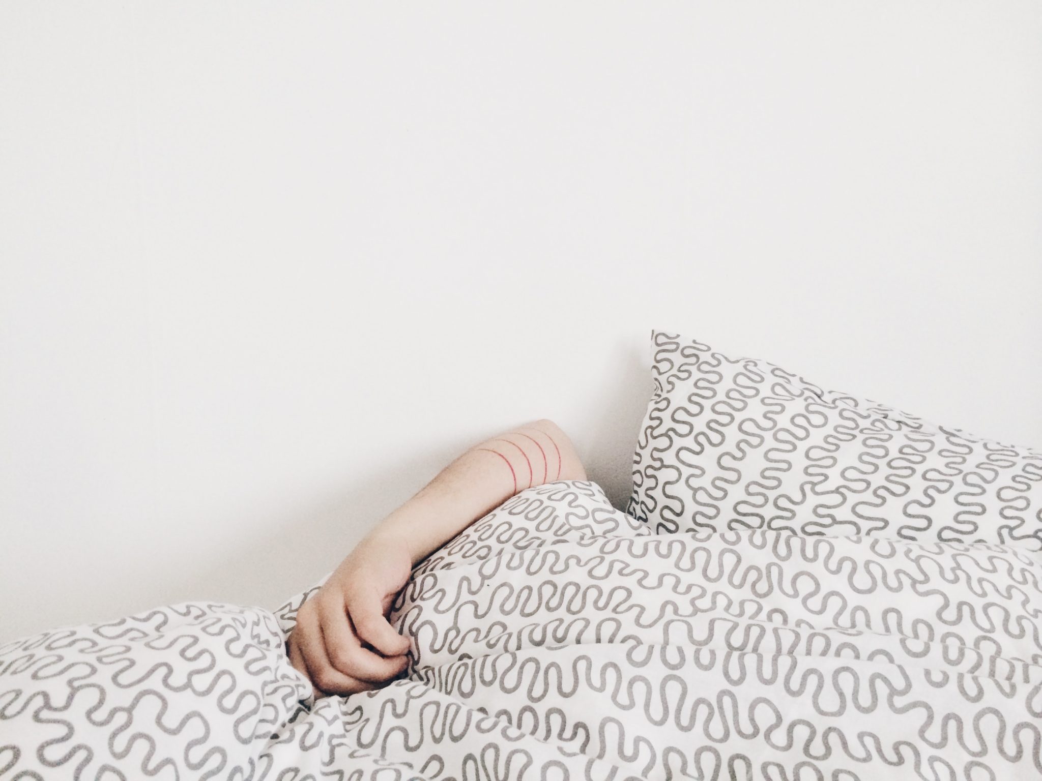 image of person sleeping under the covers 