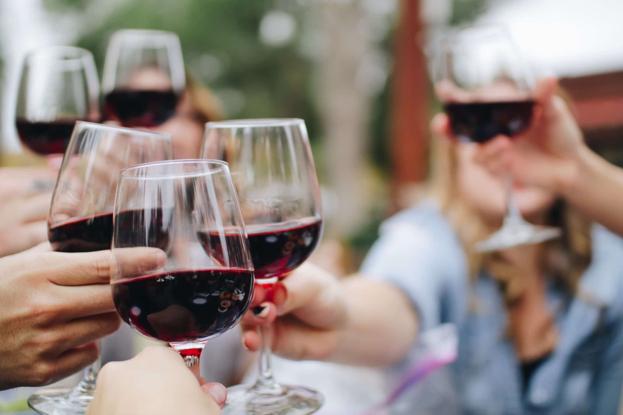 group of people "cheersing" with glasses of wine