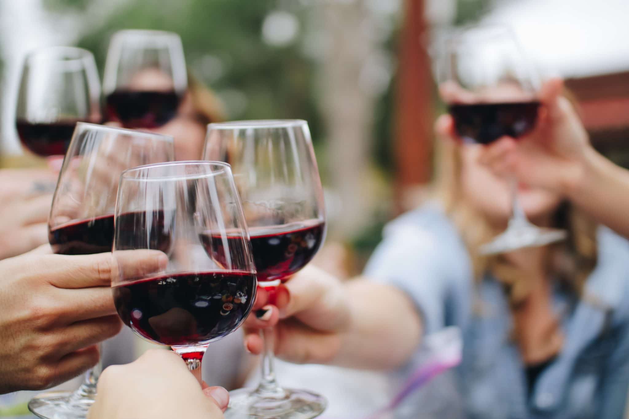 group of people "cheersing" with glasses of wine 