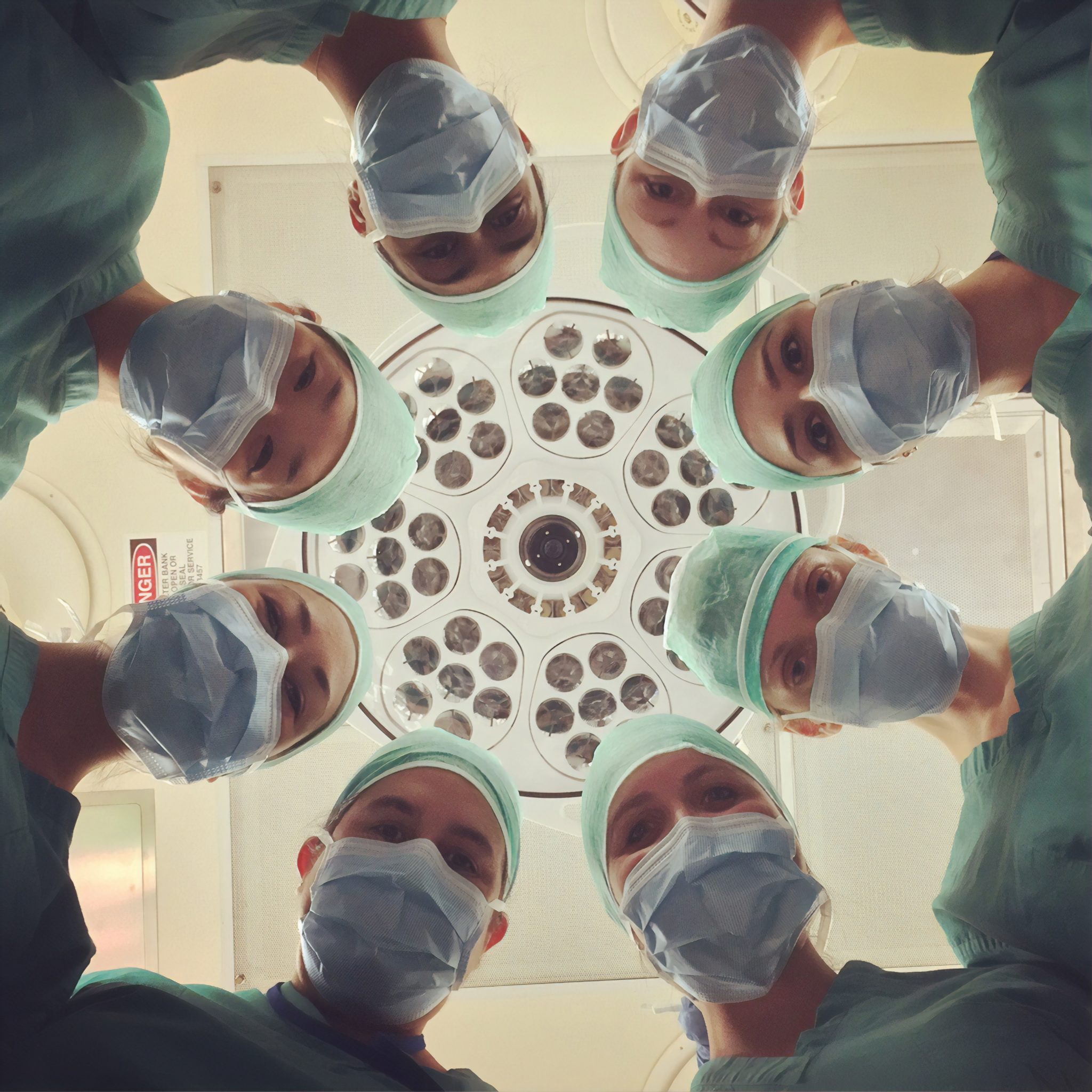 patient's perspective looking up at multiple doctors wearing masks during bariatric surgery