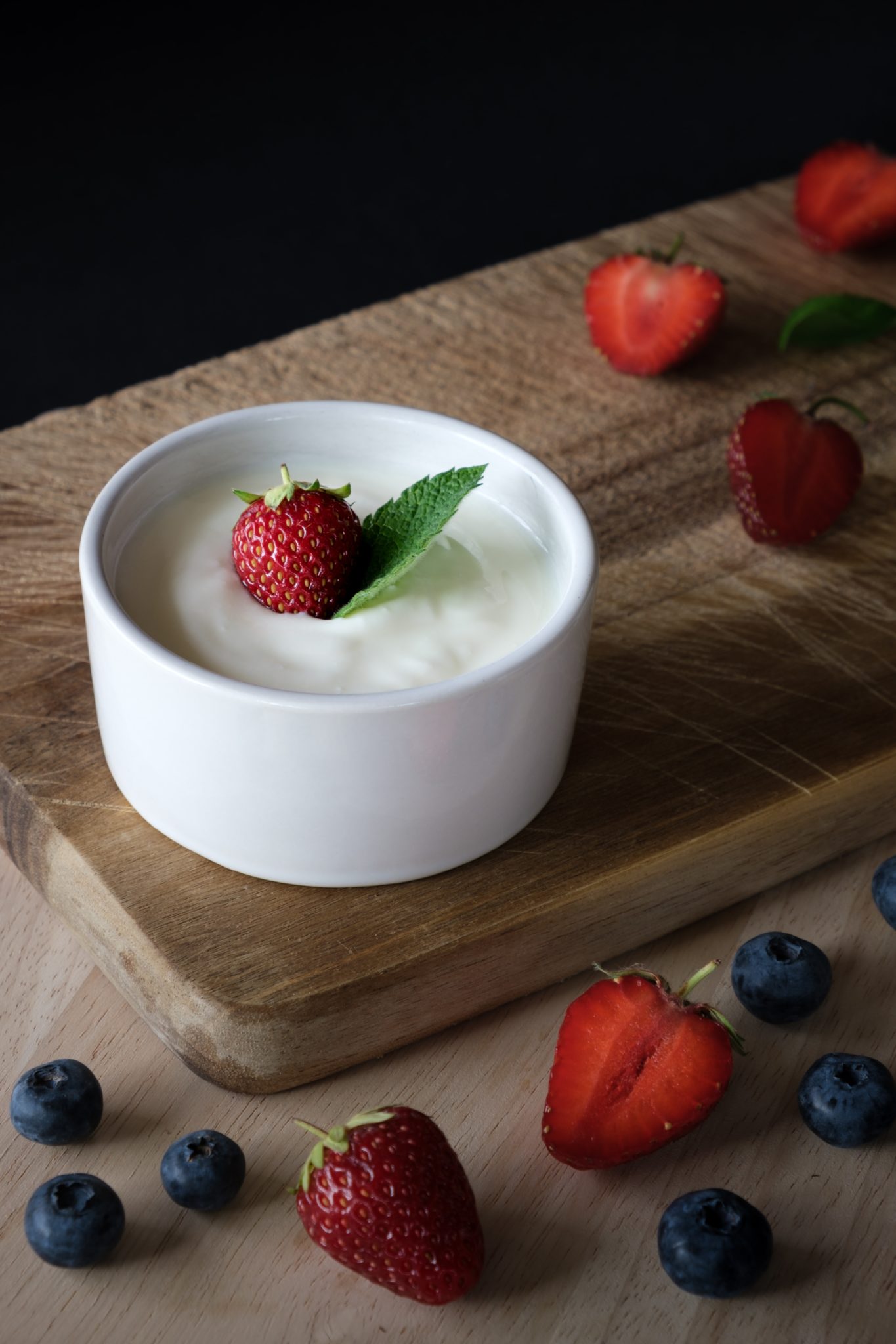 Yogurt that contains probiotics for kids in white bowl with berries.