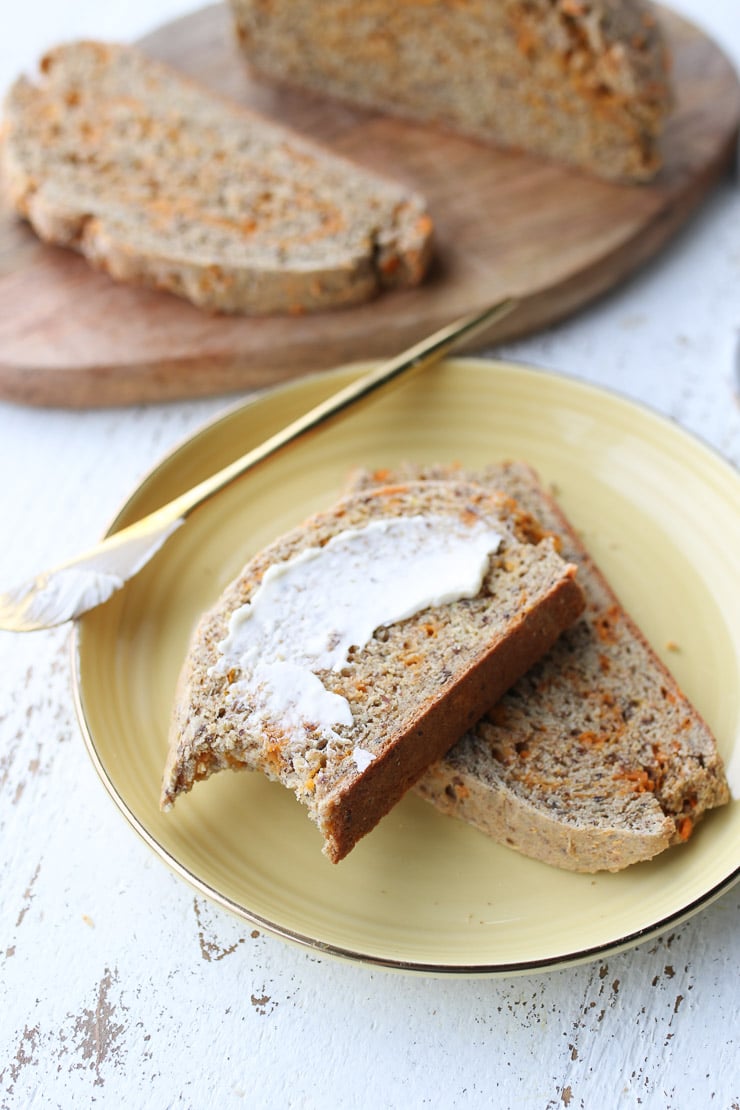 two slices of cheesy soda bread on a yellow plate with butter on top 