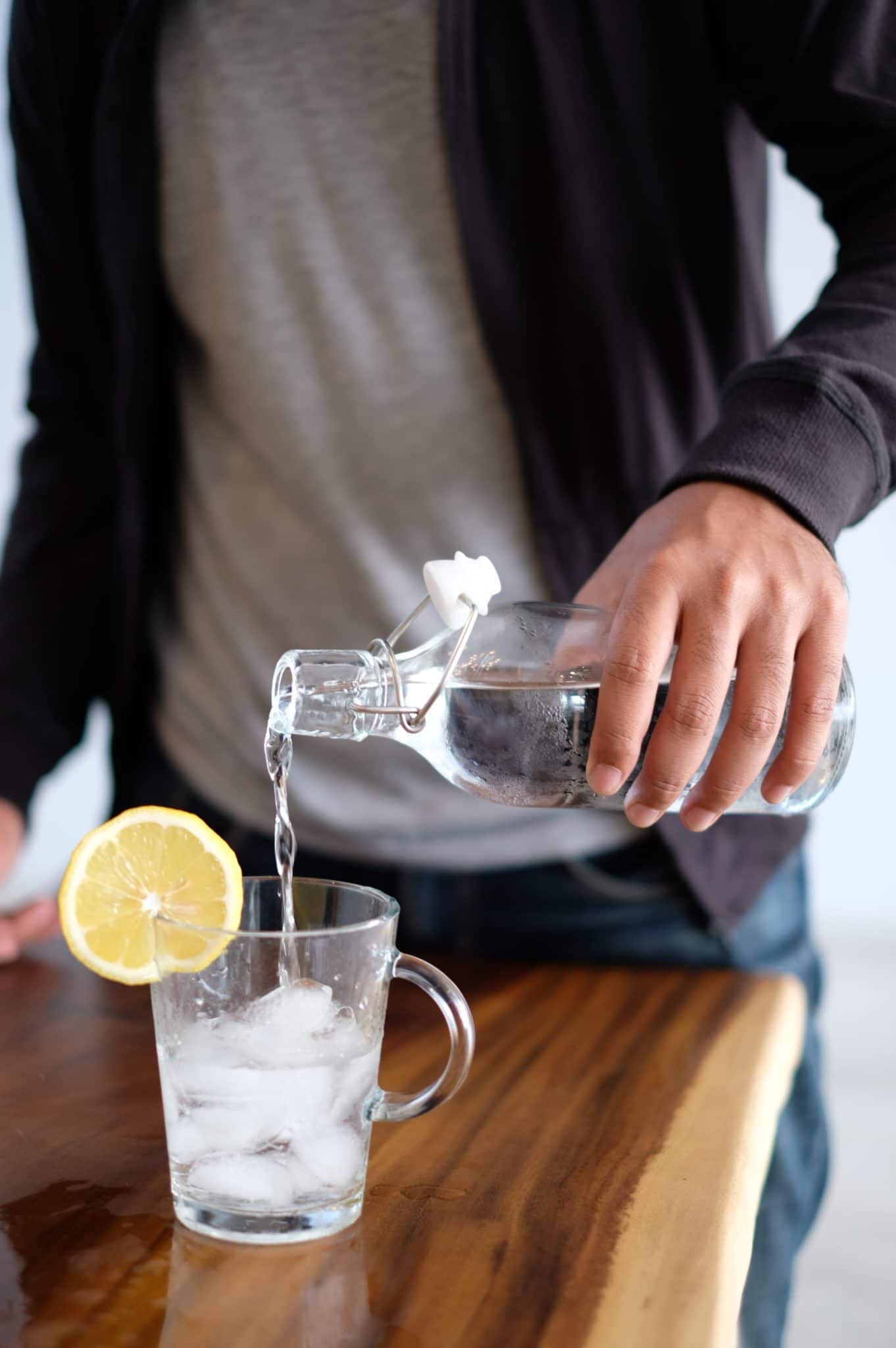 individual pouring a glass of water to drink while eating