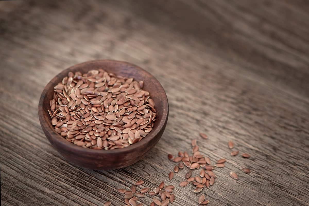 close up of whole flaxseed in a bowl for seed cycling