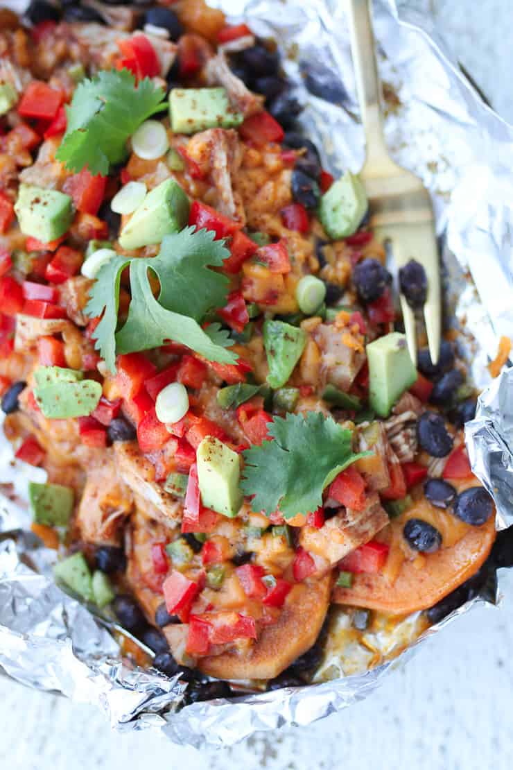 sweet potato nachos garnished with cilantro in a foil pack 