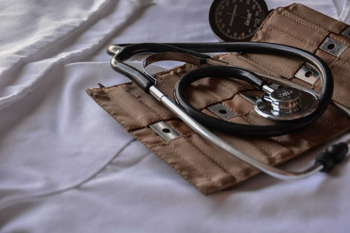 A black stethoscope on top of a brown case.