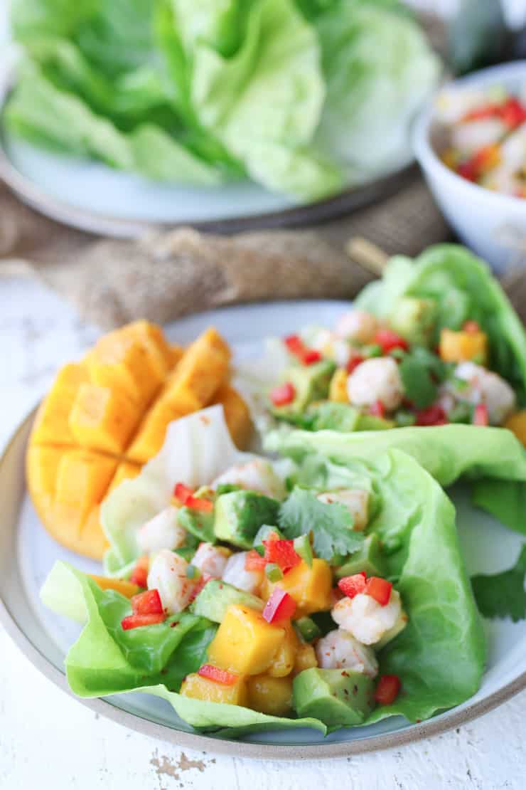 shrimp avocado salad on a white plate garnished with mango 
