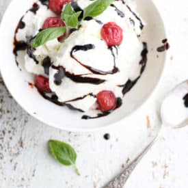 ice cream in a white bowl drizzled with balsamic glaze