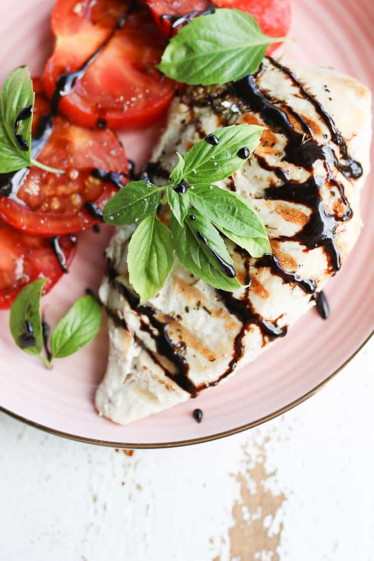 chicken breast and tomatoes on a pink plate 