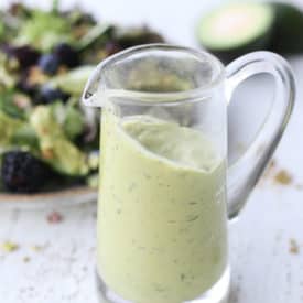 close up of avocado dressing in a clear glass