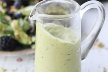 close up of avocado dressing in a clear glass