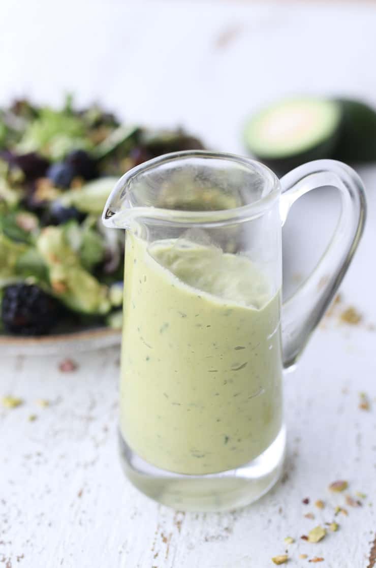 Close up of avocado salad dressing in a clear glass.