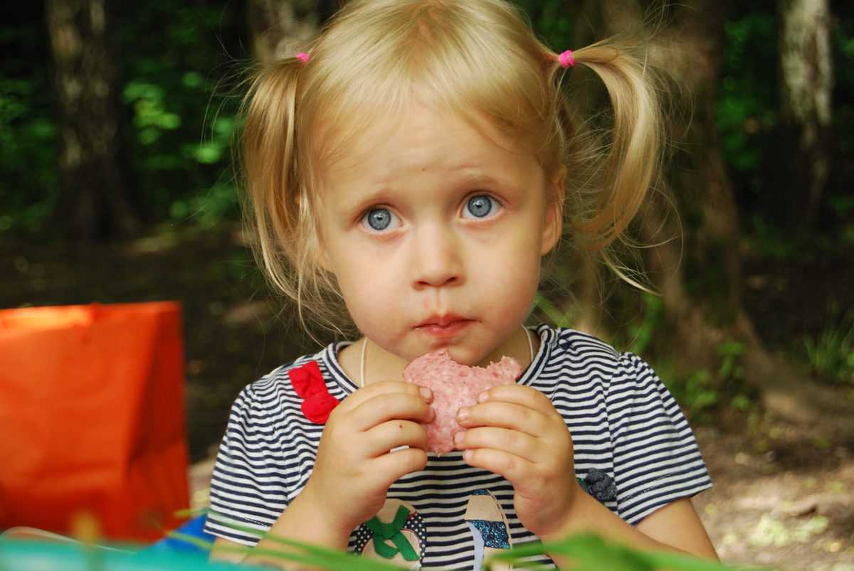 a little girl eating a donut 