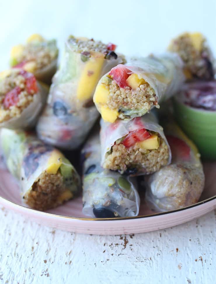 rice paper wraps with fruit and quinoa on a pink plate