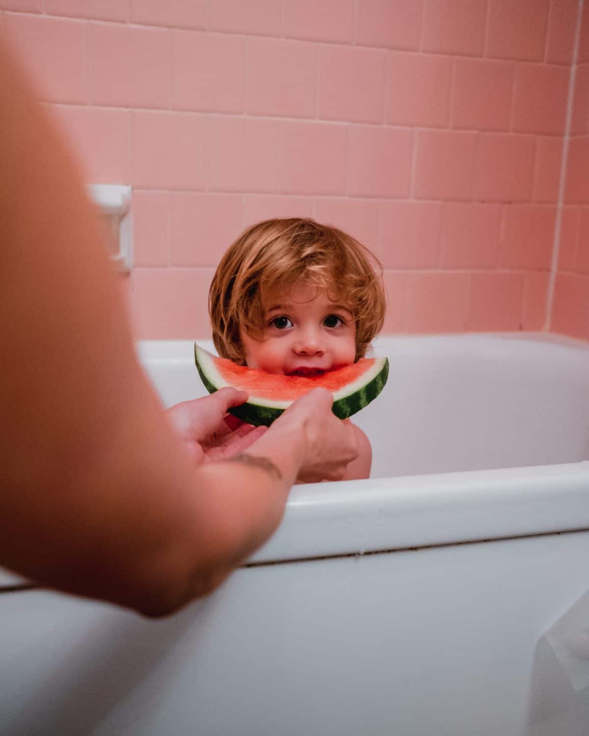 a picky eater being fed watermelon in the bathtub 