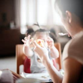 a mother feeding her picky toddler