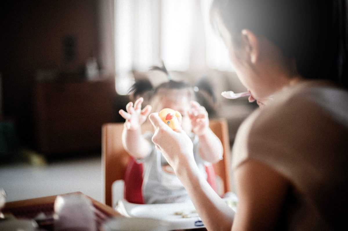 a mother feeding her picky toddler 