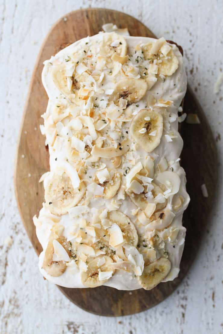 Overhead view of a banana carrot cake with cream cheese frosting.