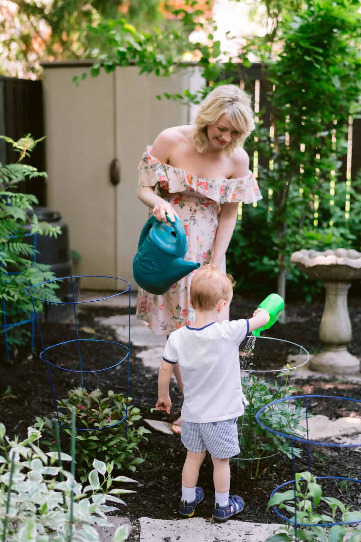 Abbey and Baby E outside watering the plants 