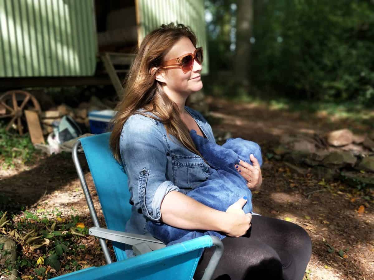 A woman sitting outside breastfeeding.