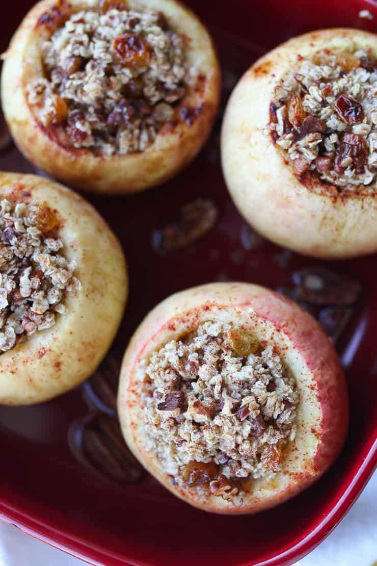 Four baked apples in a baking dish.