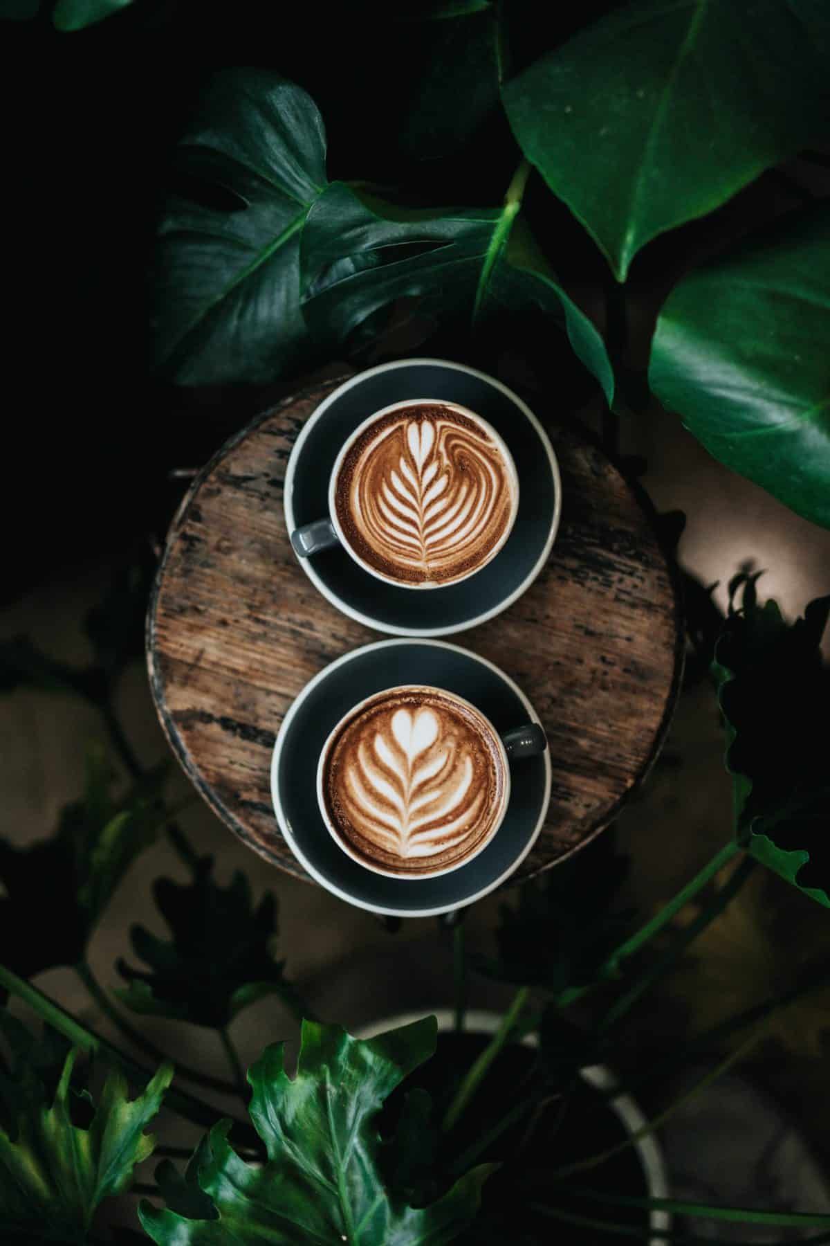 Birds eye view of two lattes on a table.