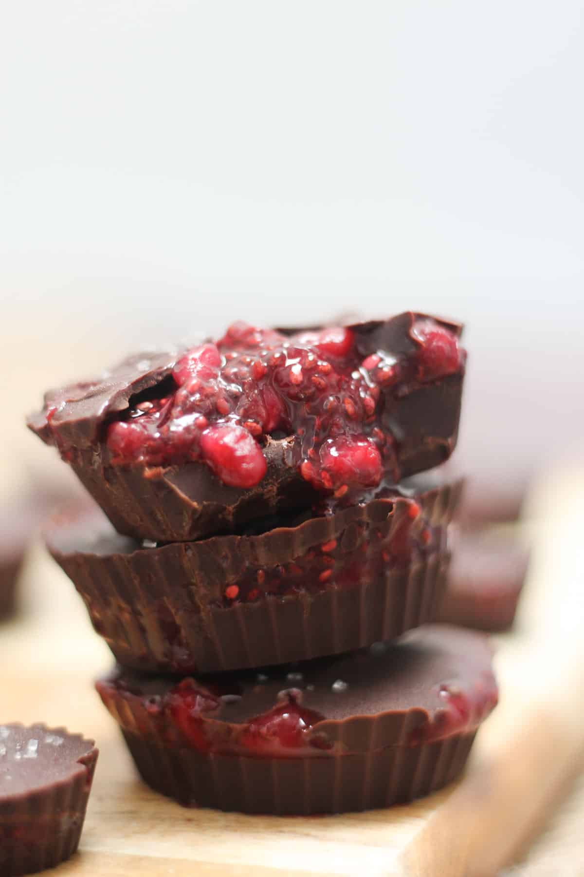 Three chocolate cups stacked on top of each other which chia jam pouring out from the sides.