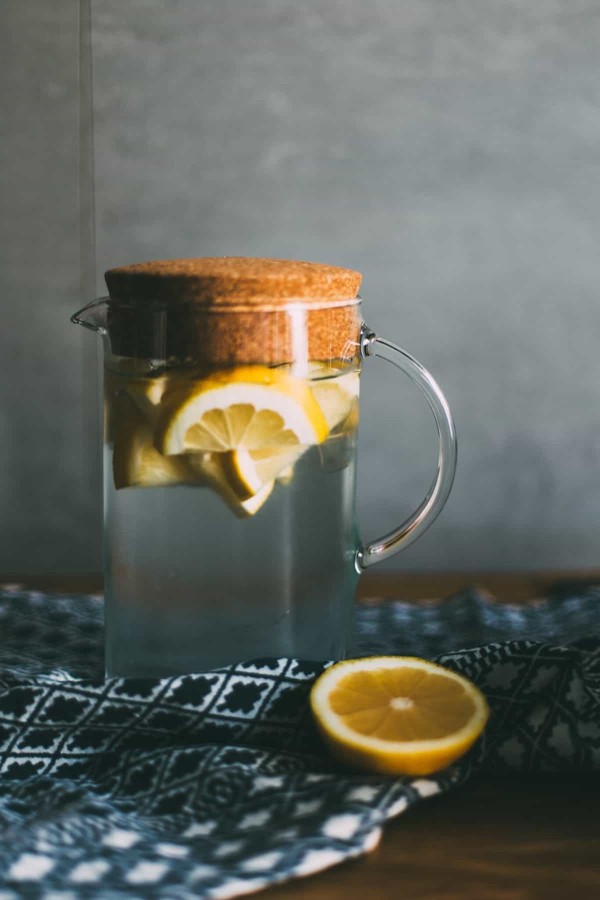 A tall pitcher with citrus wedges. 