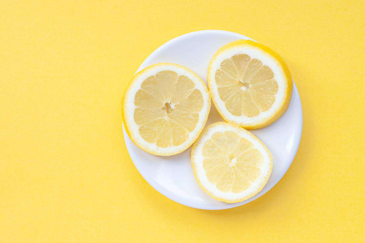 Three lemon slices on a white plate. 