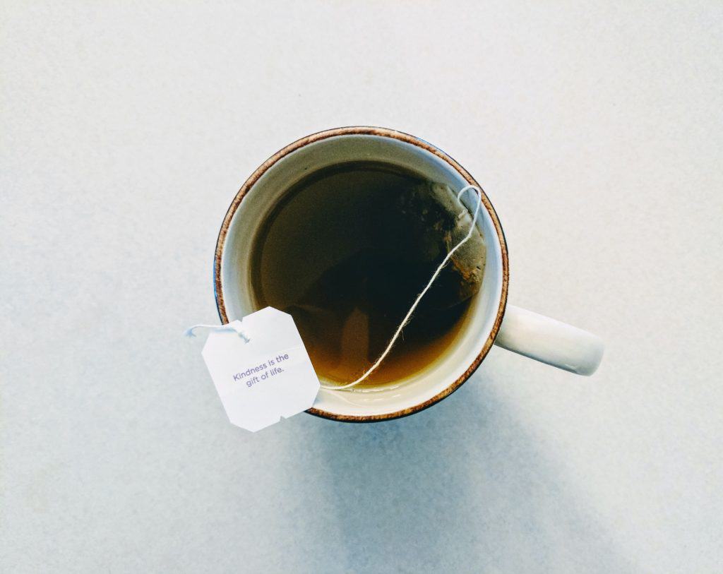 birds eye view of a tea bag steeping in a white mug.