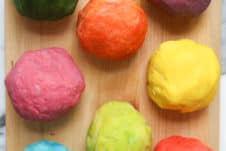 several balls of homemade playdough on a wooden board