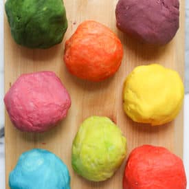 several balls of homemade playdough on a wooden board