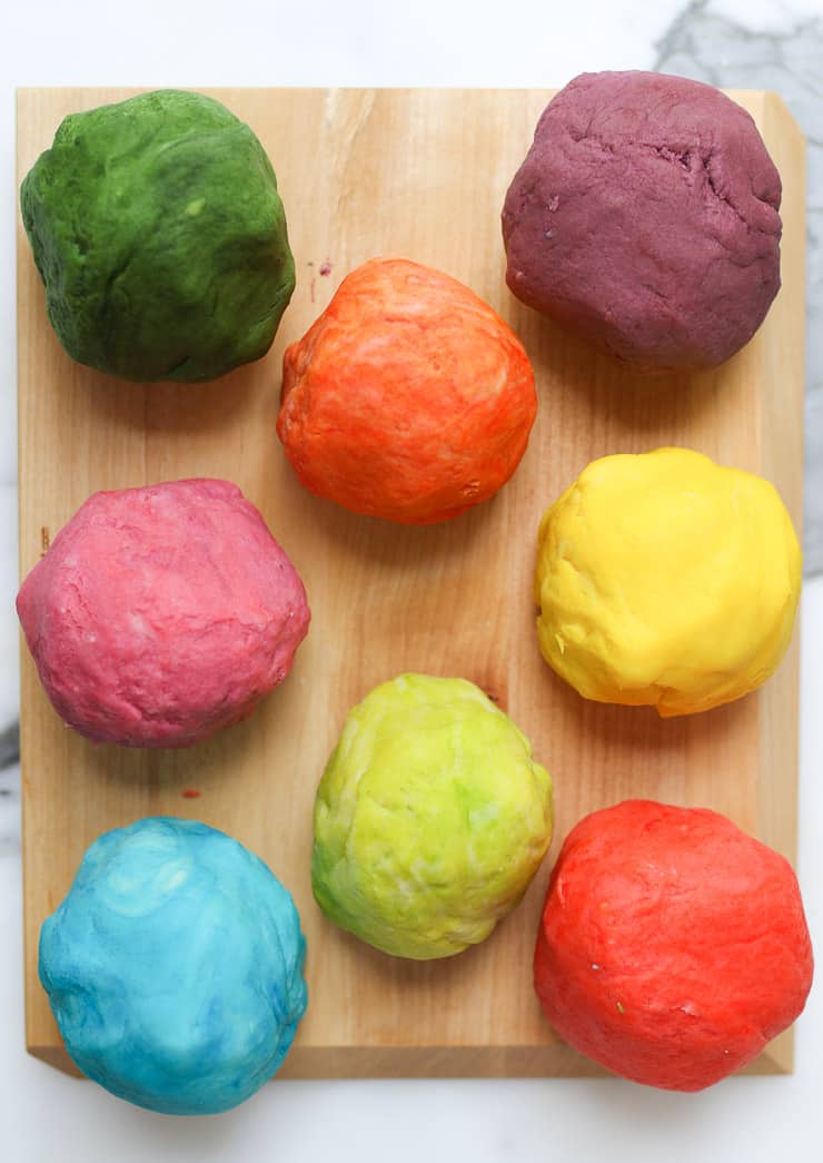 several balls of homemade playdough on a wooden board