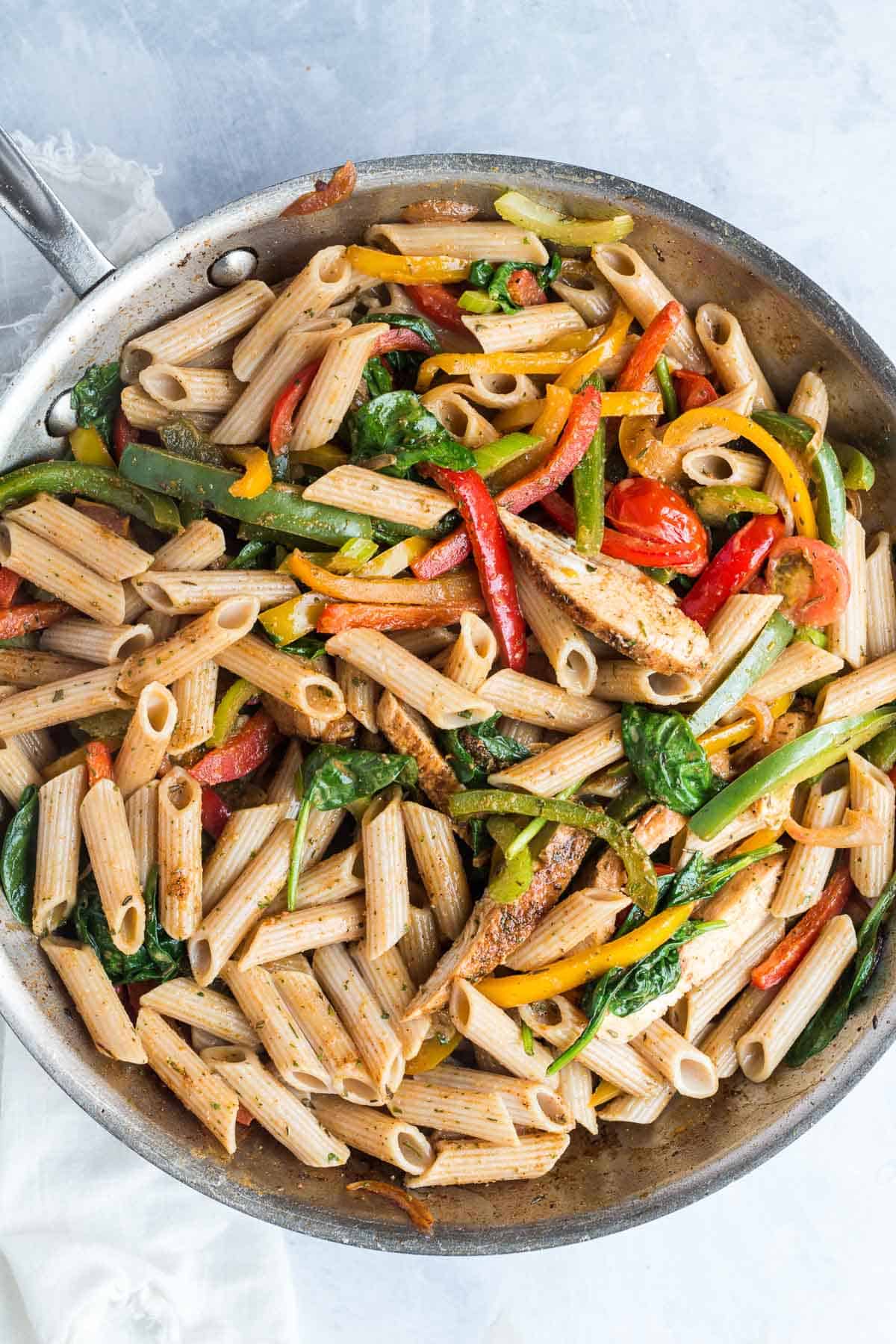 Pasta and veggies in a grey pan.