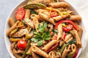 pinterest image of jerk chicken pasta in a white bowl.