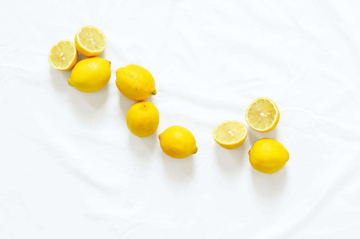 Several lemons with some cut in half. 