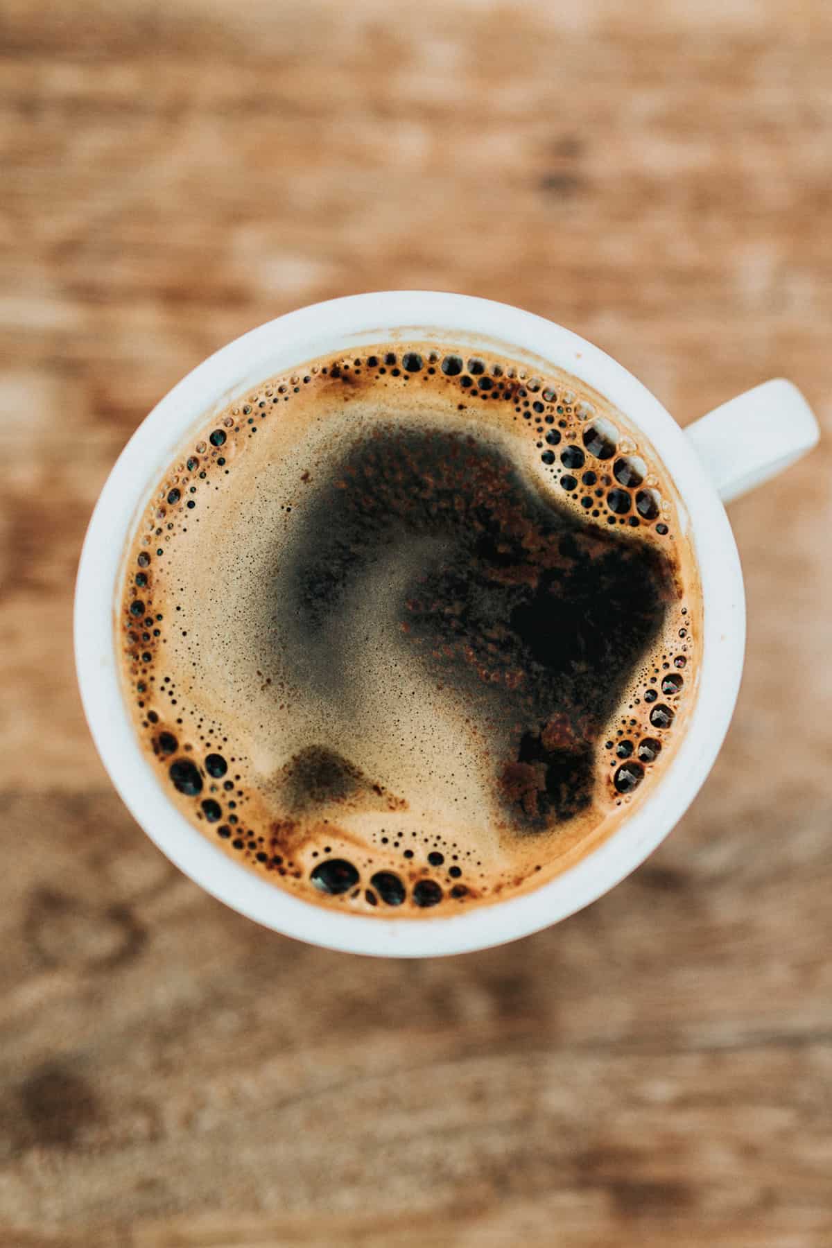 Birds eye view image of black coffee while intermittent fasting in a white mug . 