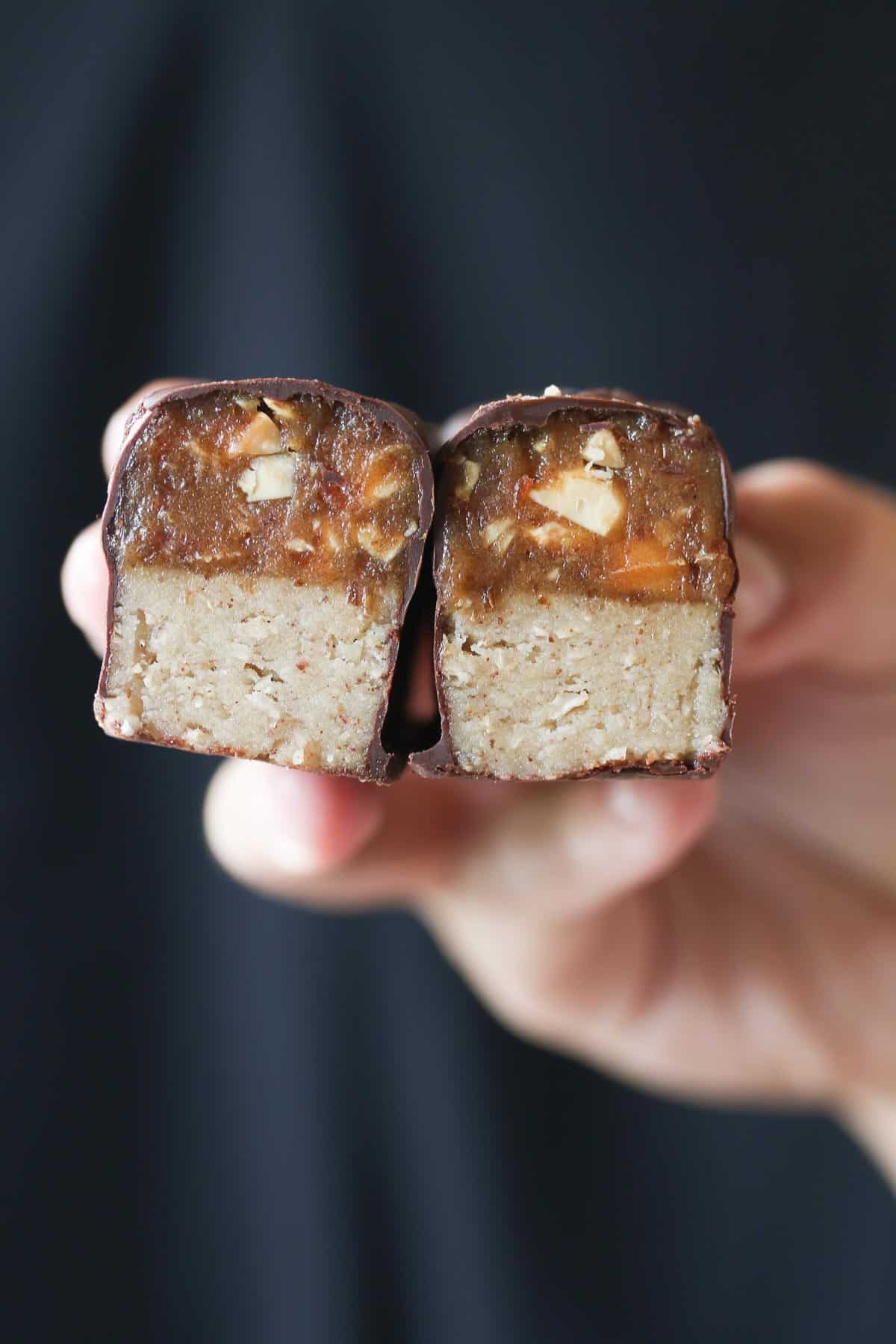 Hand showing the cross section of a homemade snickers bar