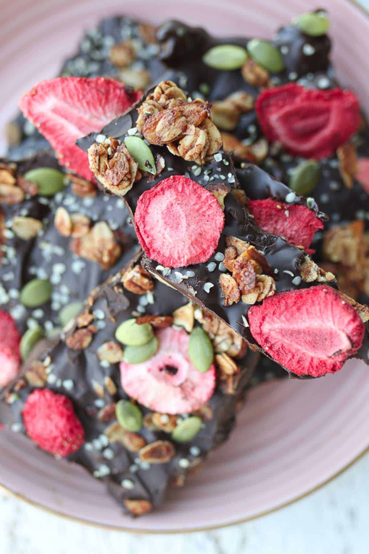 Almond chocolate bark pieces on a pink plate. 