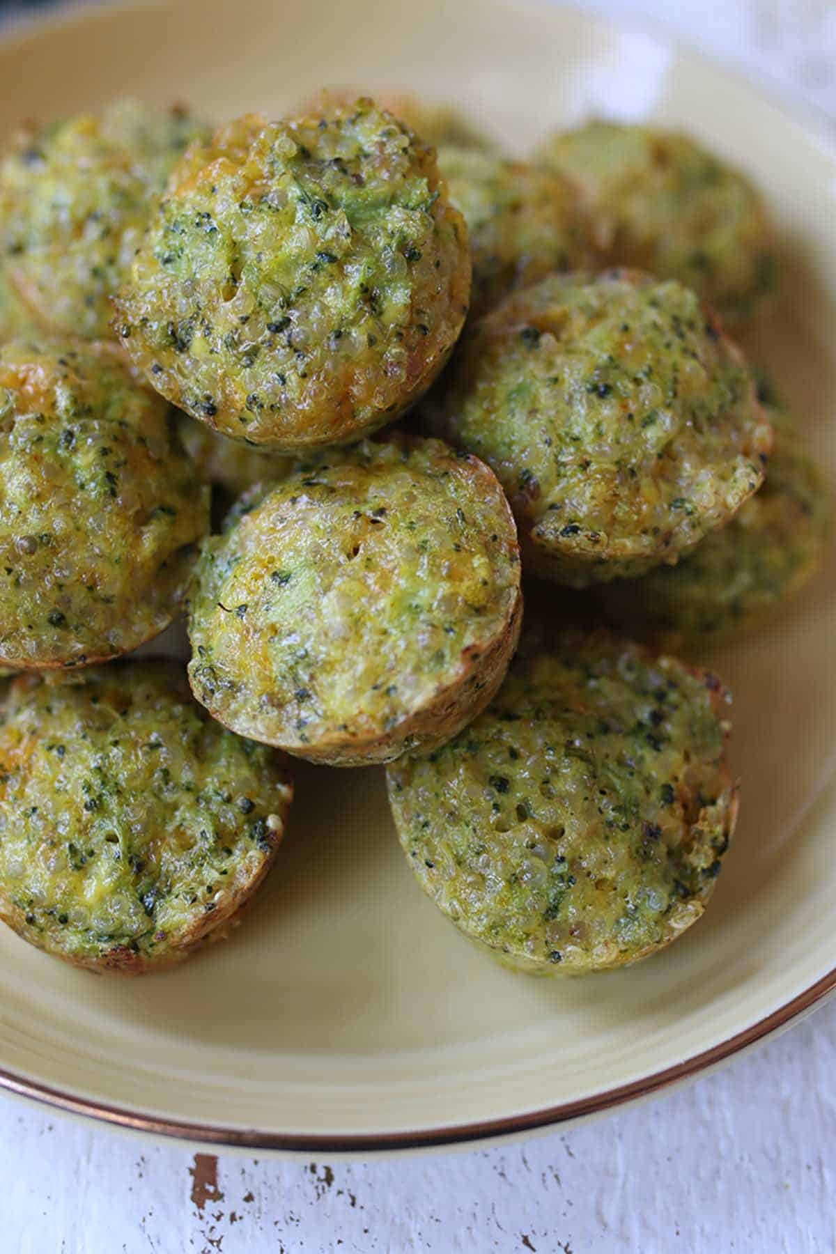 Several mini broccoli and cheese egg muffins on a yellow plate.