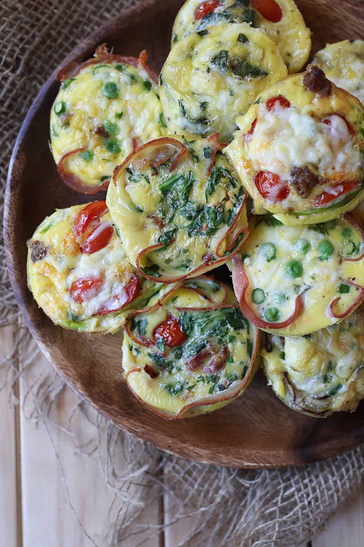 Several egg cups on a wooden plate.