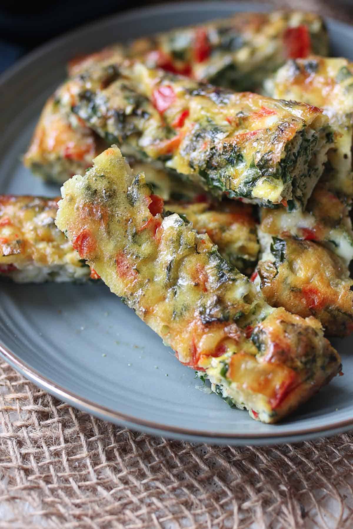 Several frittata fingers on a blue plate. 