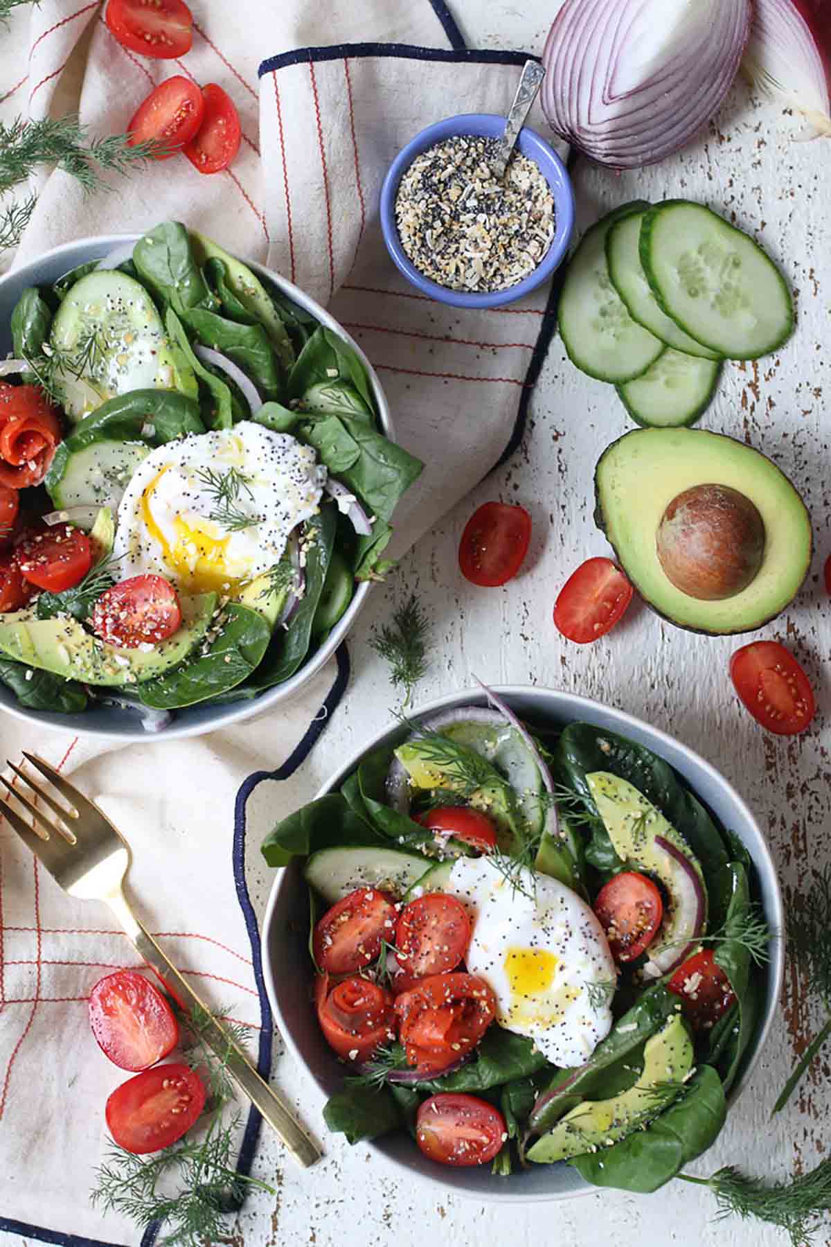 Birds eye view of two bowls of salad with a poached egg on top. 