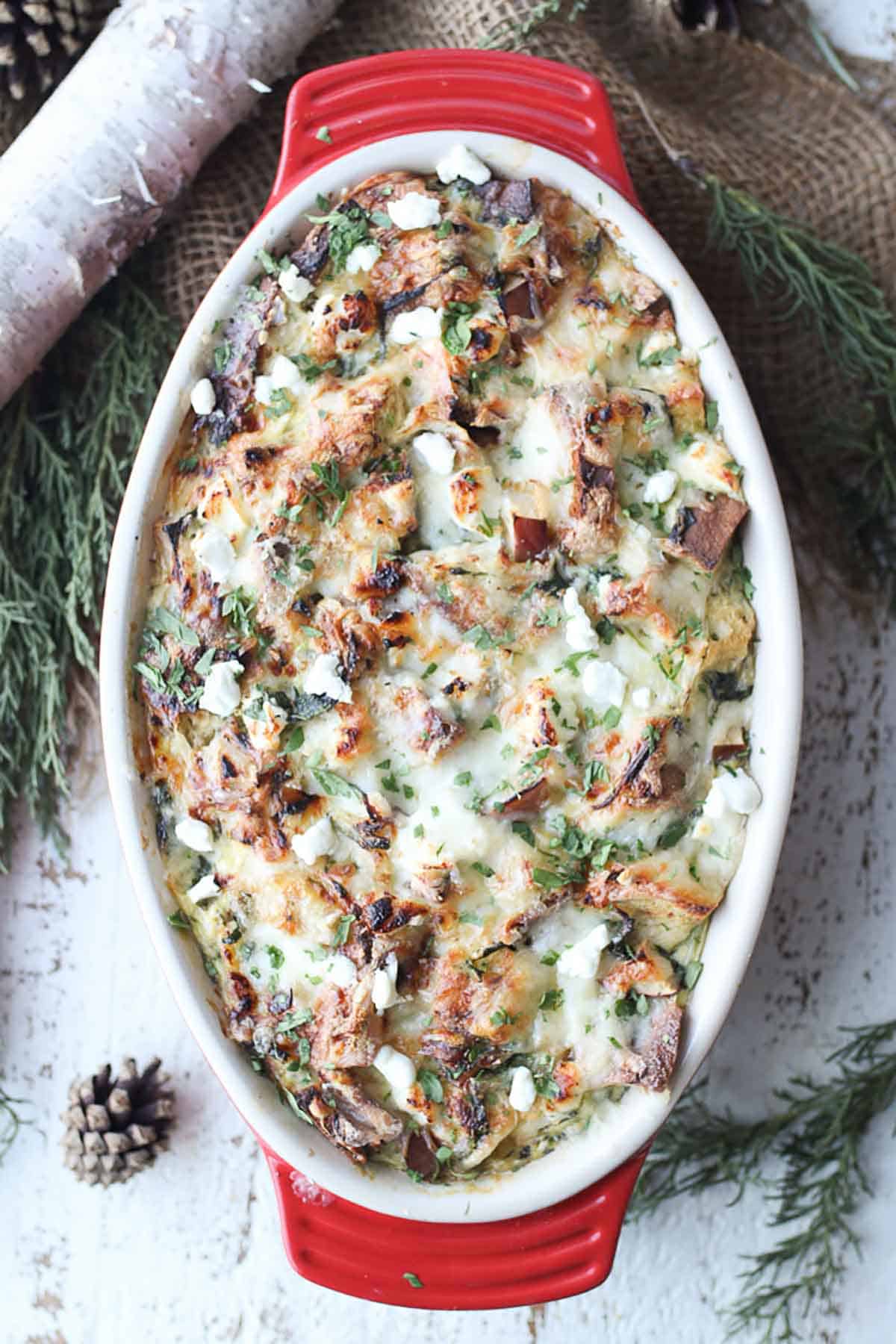 Birds eye view of strata in a red casserole dish topped with parsley. 