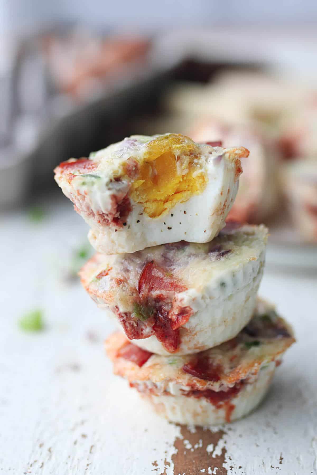 Three pizza egg muffins stacked on top of one another.